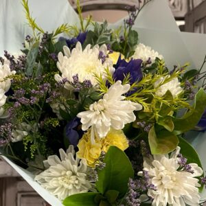 A lush bouquet of fresh seasonal flowers in blues, whites and lemons.