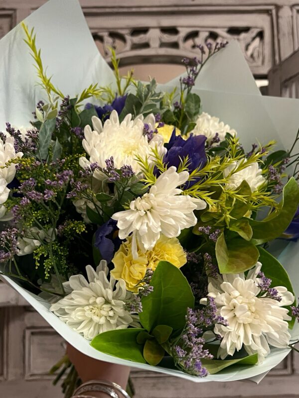 A lush bouquet of fresh seasonal flowers in blues, whites and lemons.