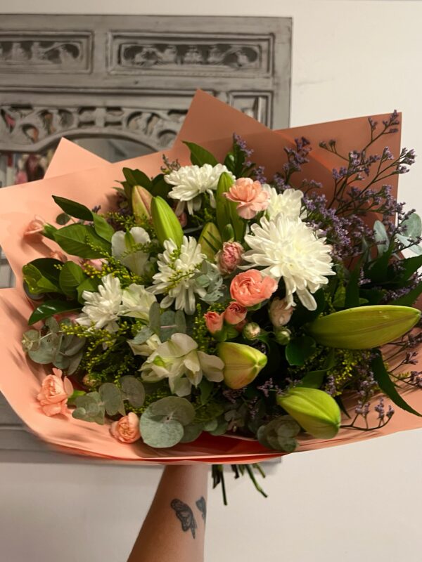 A bouquet of pink and white fresh flowers; including lilies, spray carnations, chrysanthemums, alstroemeria with greenery and flowering fill.