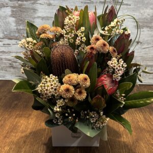 Native style flower arrangement featuring proteas, leucadendron and seasonal textured foliage in a modern design