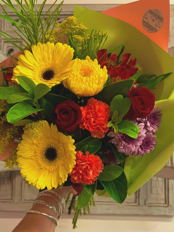 A vibrant bouquet of mix of fresh seasonal flowers - Roses, carnations, gerberas and chrysanthemums.