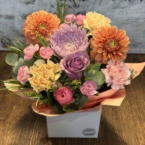 A colourful arrangement of seasonal flowers called Rainbow Surprise