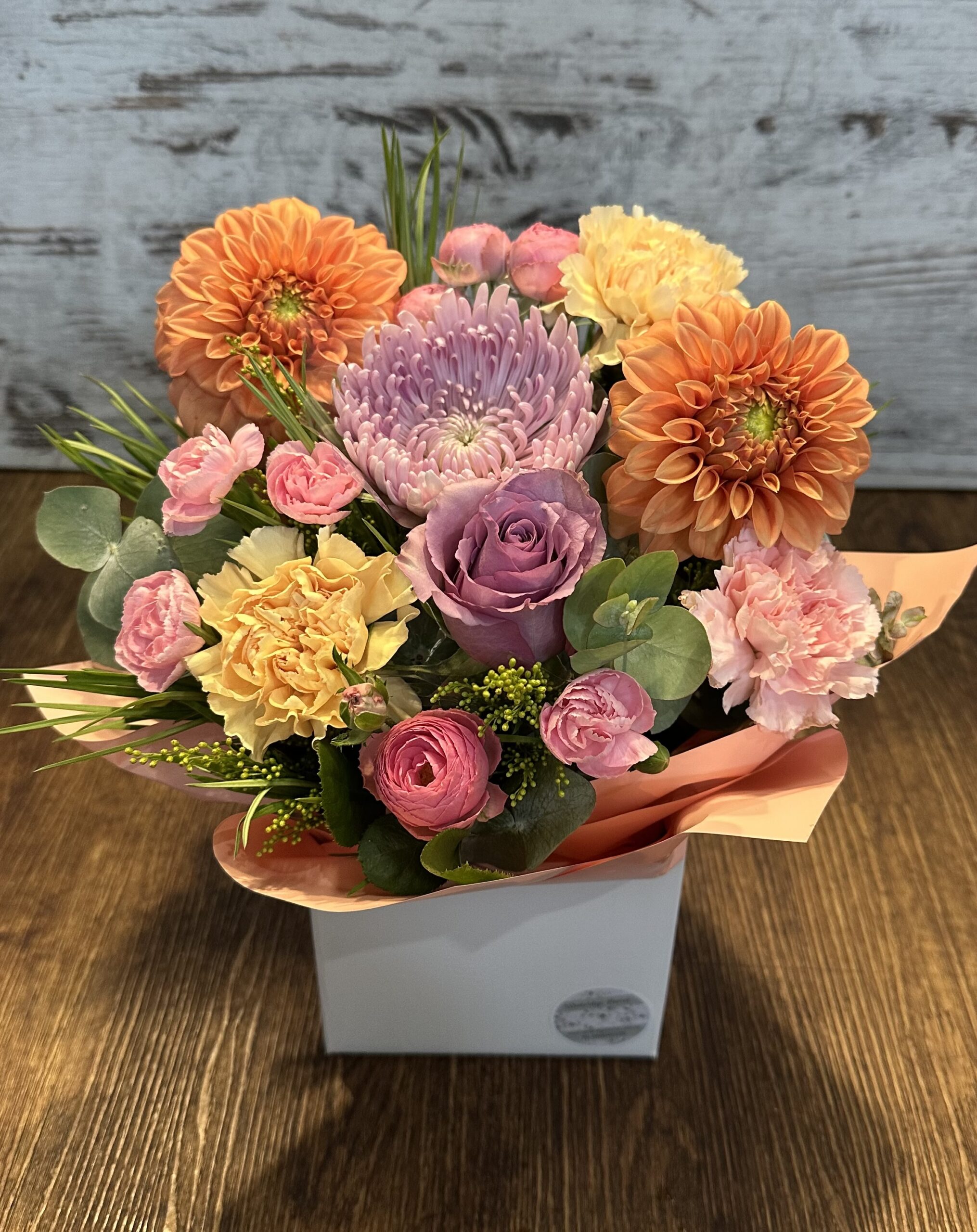 A colourful arrangement of seasonal flowers called Rainbow Surprise