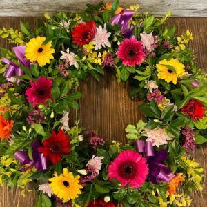 A wreath made with breath seasonal flowers including gerberas and chrysanthemums.