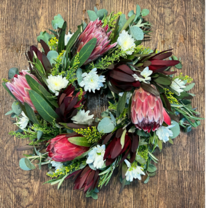 A wreath featuring beautiful array of proteas, Leucadendron, chrysanthemums and gum.