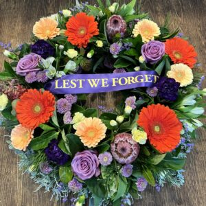 Ring of Love Anzac Wreath in purple, red and orange blooms