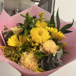A vibrant bouquet of mixed fresh seasonal flowers in shades of yellow.